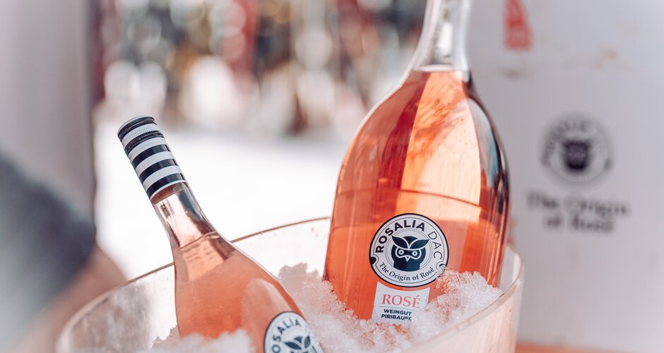 Zwei Roséwein-Flaschen der Marke Rosalia DAC liegen in einem Eiskübel mit Crushed Ice