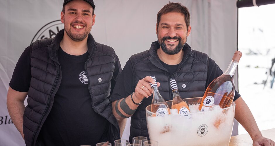 Zwei Männer hinter einem Stand mit Rosalia DAC Roséwein in Eiskübel und mehreren Weingläsern
