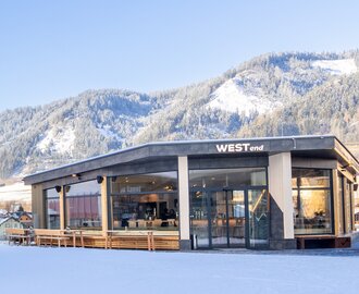 Modern WESTend Lounge with large windows, snowy mountain backdrop and clear blue sky. | © Harald Steiner