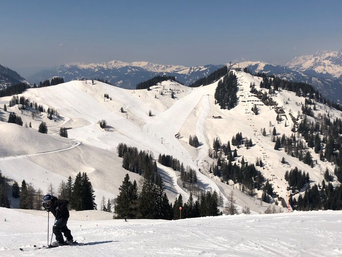 Skier enjoys the view of snow-covered mountains and slopes. | © Anna Pilz