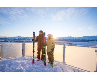 Two skiers with skis on snowy platform at sunrise in Dorfgastein | © Dorfgasteiner Bergbahnen AG/Christoph Oberschneider