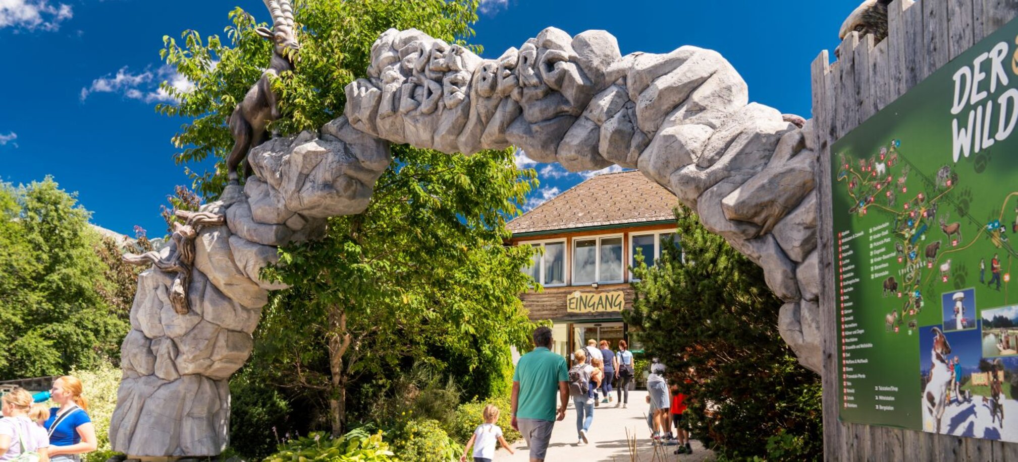Visitors walk through the stone entrance gate to Wilde Berg in Mautern with animal figures. | © Christine Höflehner
