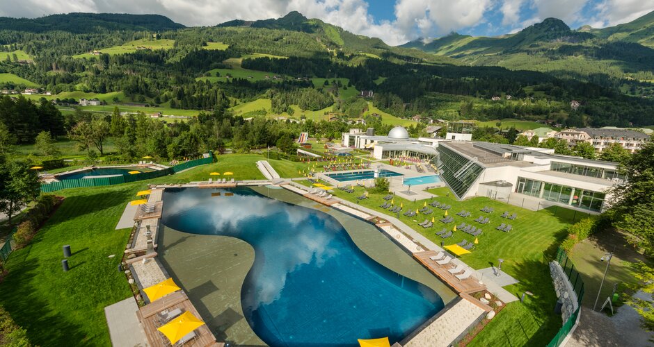 View of Alpentherme Gastein with large thermal lake, sunbathing lawns and surrounding mountain scenery in summer | © Alpentherme Gastein, Wolkersdorfer