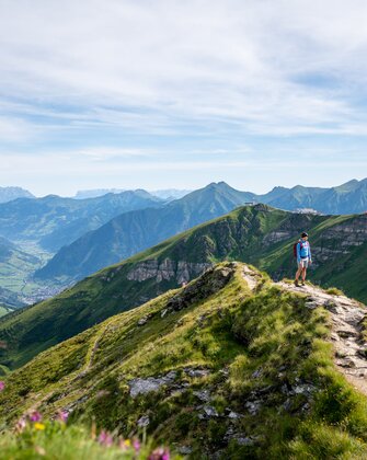 Hiker on a ridge trail at Stubnerkogel with a wide view over the green Gastein Valley and the surrounding mountain peaks | © Gasteinertal Tourismus GmbH, Christoph Oberschneider