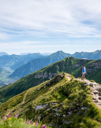 Hiker on a ridge trail at Stubnerkogel with a wide view over the green Gastein Valley and the surrounding mountain peaks | © Gasteinertal Tourismus GmbH, Christoph Oberschneider