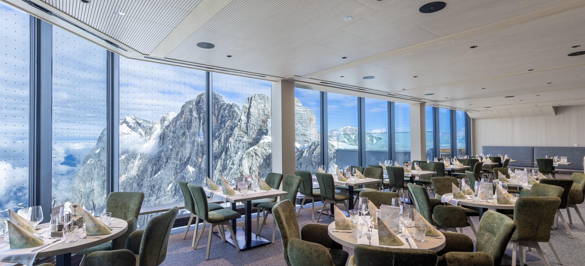 Restaurant mit großen Fenstern und Bergblick auf schneebedeckte Gipfel am Dachstein. | © Harald Steiner
