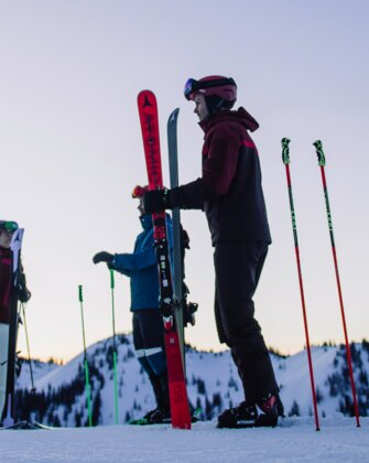 Four skiers stand on a snowy slope under a violet sky. | © Ski amadé