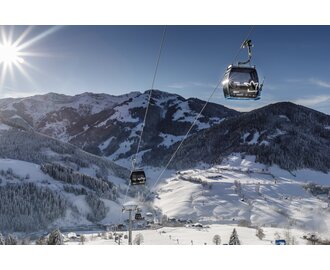 Sonnbergbahn gondolas move above snowy slopes near Maria Alm in winter sunshine | © www.felsch-foto.at